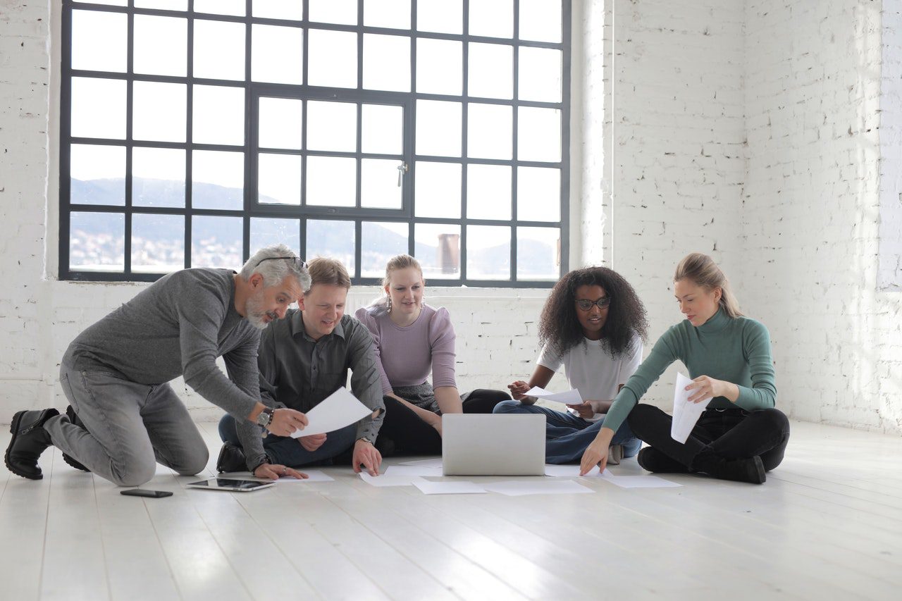 Team discussing digital marketing sitting on floor