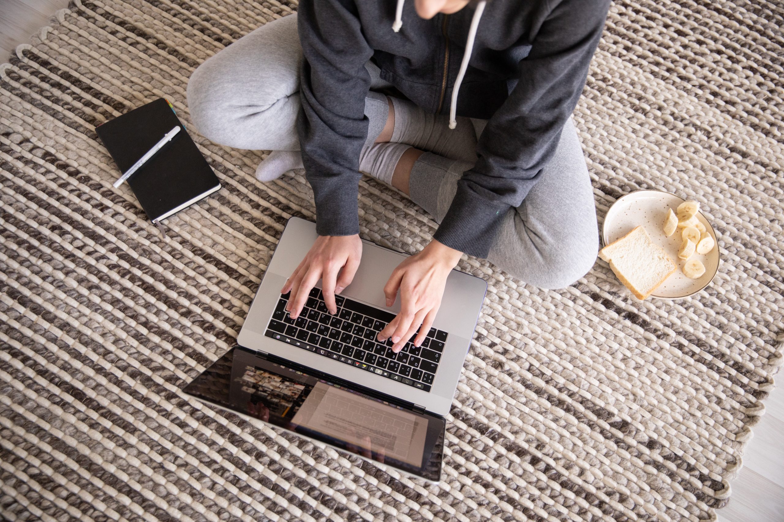 Person sitting on the floor typing some email marketing copy