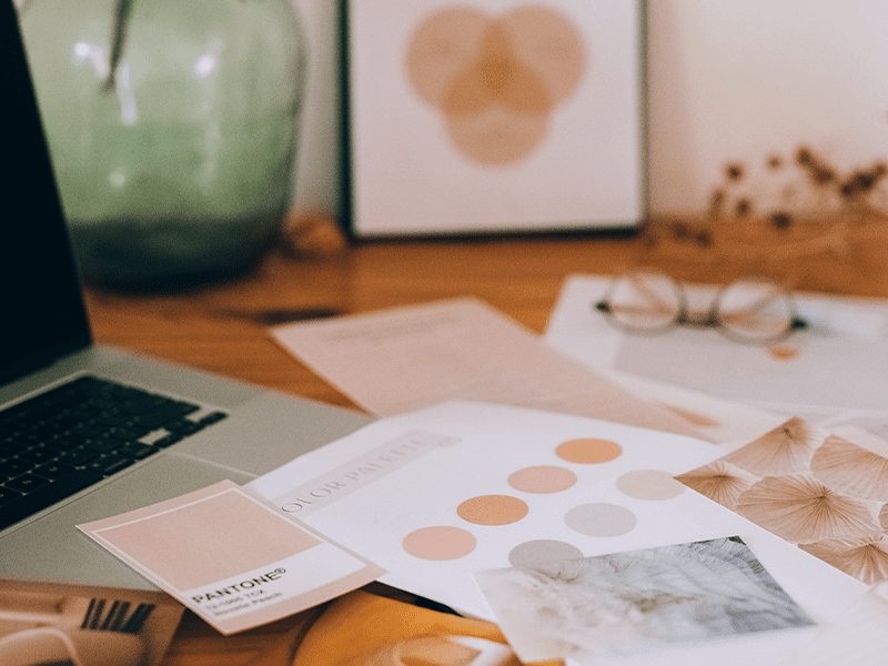 Design & Content display of colour palettes on pieces of paper and a laptop