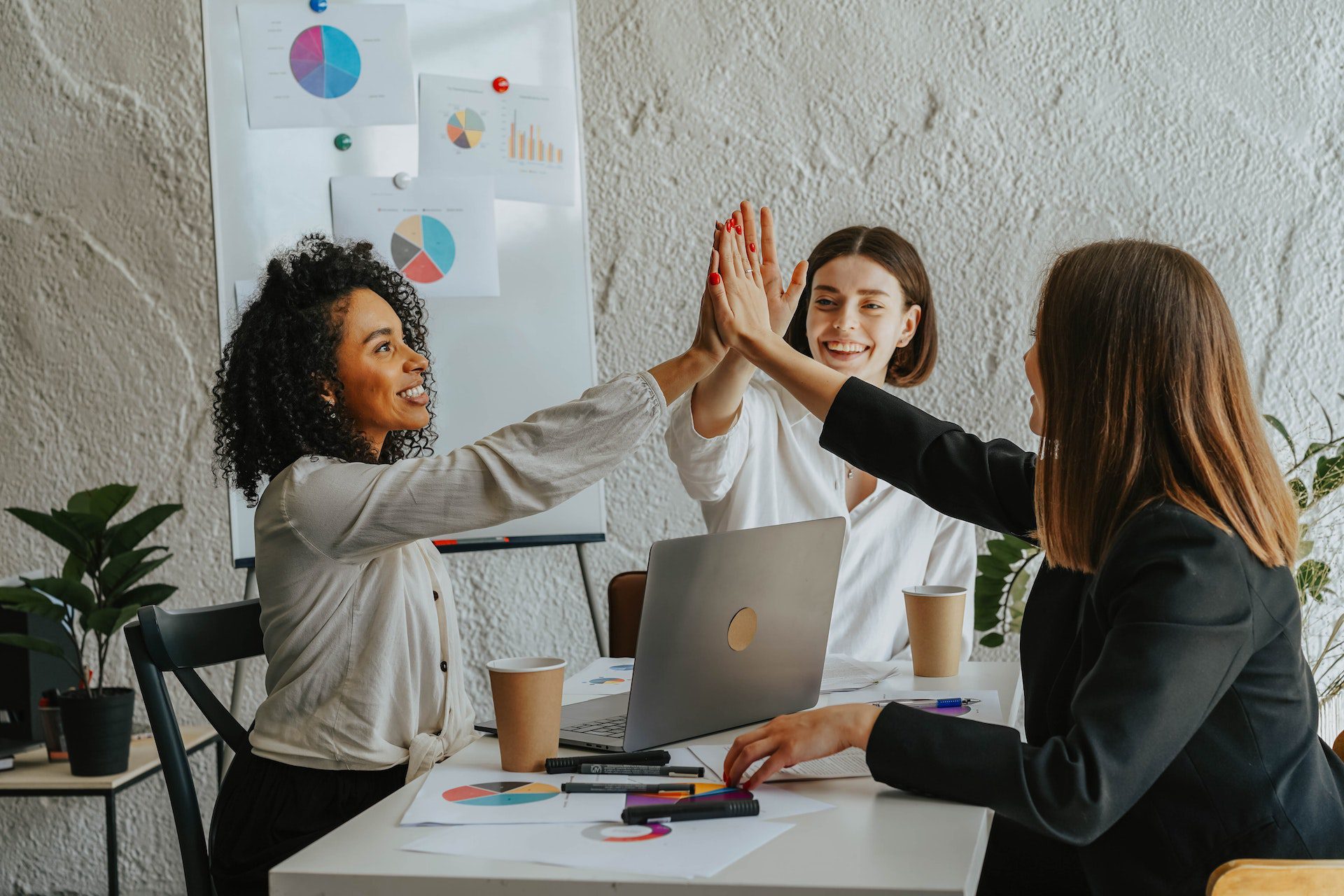 group of women high-fiving at a digital marketing agency