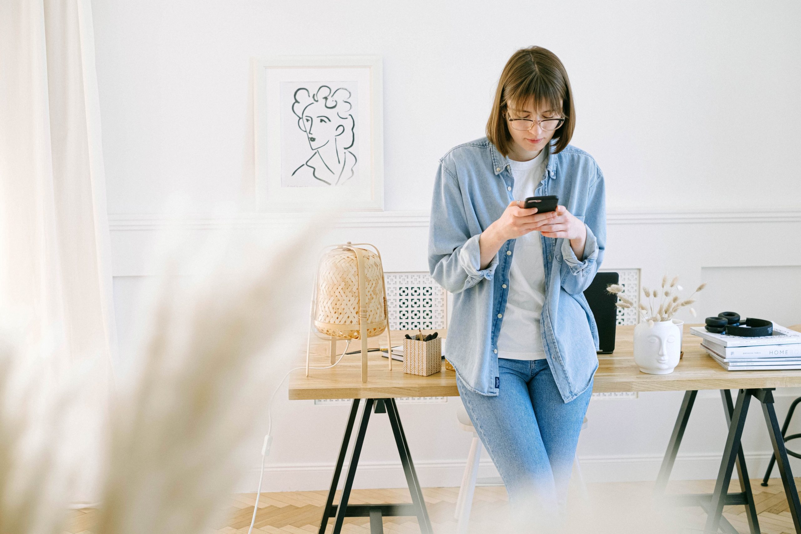 Woman looking at social media on phone in home office