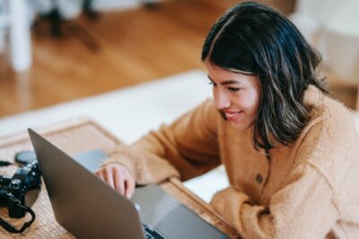 Woman sitting at laptop thinking about Facebook ad types