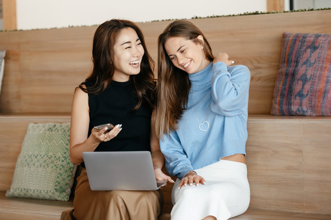 Two women discussing data privacy around a laptop