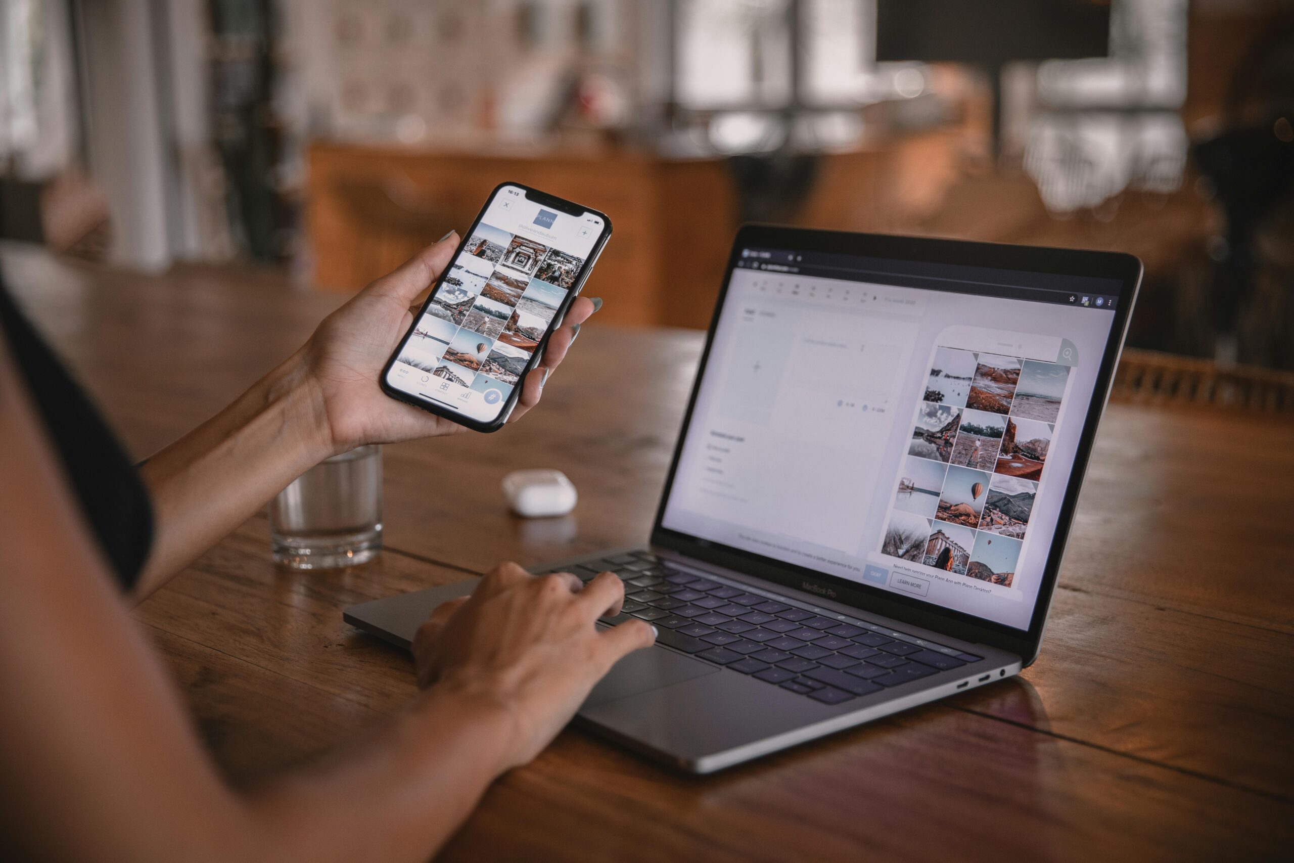 Woman using a laptop to schedule social media posts and a phone to check social media posts