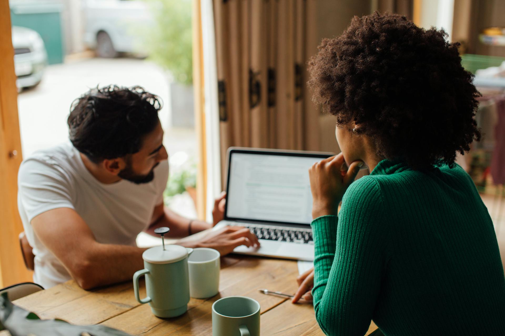 Two people looking at a static website on a laptop