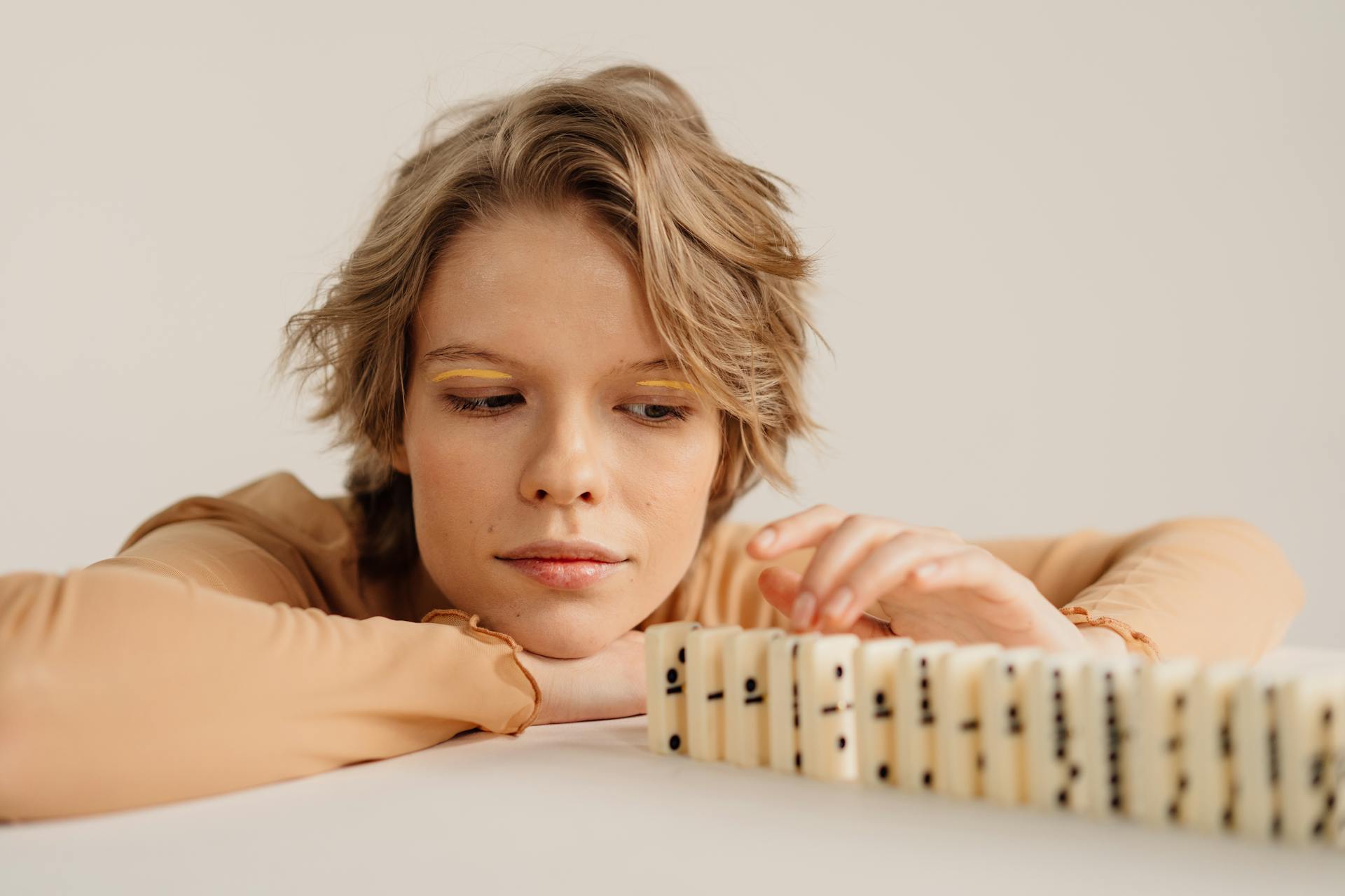 Woman giving a row of dominoes a considered look.